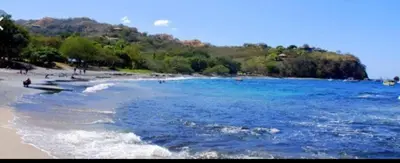 a beach with people swimming in the water at Renovated apartment in Las Palmas in Coco