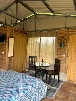 a bedroom with a bed and a table and chairs at Cabañas venado in Venado