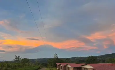 a cloudy sky with houses in a field at Cabañas venado in Venado