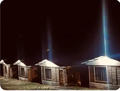 a row of houses at night with a beam of lights at Cabañas venado in Venado