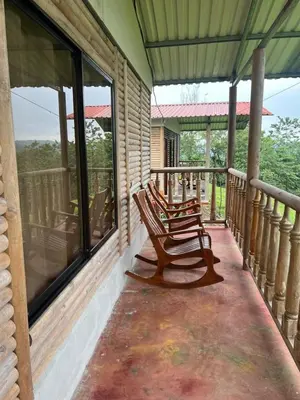 two rocking chairs sitting on the porch of a house at Cabañas venado in Venado