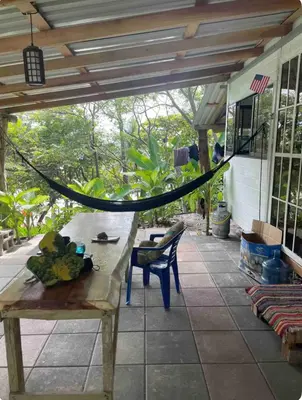 a porch with a wooden table with fruit on it at Beachfront tiny bungalow in Cóbano
