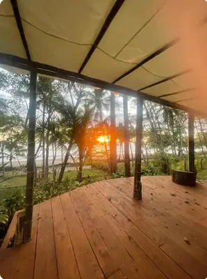 a view from the inside of a building with a wooden deck at Beachfront sunset Bungalow in Boca de Ario