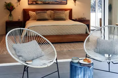 a bedroom with two chairs and a bed at CasaMAR Santa Teresa on the Beach in Carmen