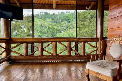 a room with a large window with a television in it at Cabaña Vistas Paraíso in Turrialba