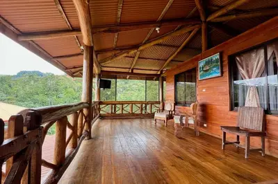 a large room with wooden flooring and a balcony at Cabaña Vistas Paraíso in Turrialba