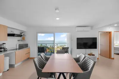 a kitchen and living room with a table and chairs at Ocean View Condo at Viva Jaco, Newly Built in Jacó
