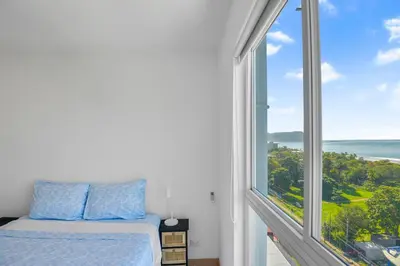a bedroom with a bed and a large window at Ocean View Condo at Viva Jaco, Newly Built in Jacó