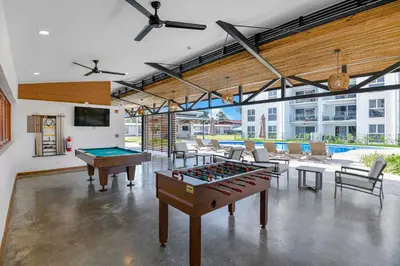 a room with ping pong tables and a tv in it at Ocean View Condo at Viva Jaco, Newly Built in Jacó