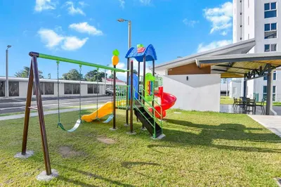 a playground in a park with a slide at Ocean View Condo at Viva Jaco, Newly Built in Jacó