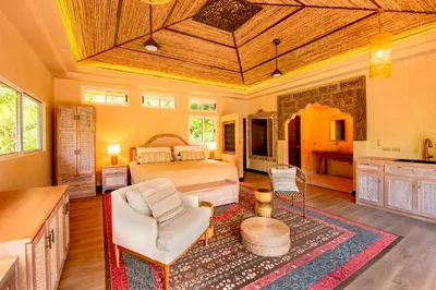 a bedroom with a bed and a couch and a table at Jazz Studio in Nosara