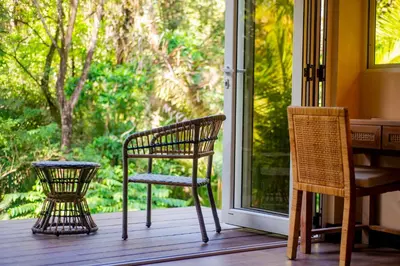 two chairs and a table on a porch with a window at Jazz Studio in Nosara