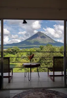 a view of a mountain from a balcony with a table and chairs at Hilltop Bungalow #1 W Spectacular Volcano View in El Fosforo