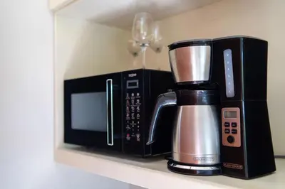 a microwave and a coffee maker on a shelf at Hilltop Bungalow #1 W Spectacular Volcano View in El Fosforo