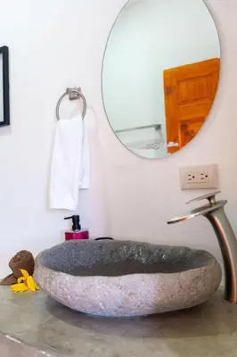 a bathroom with a stone sink and a mirror at Hilltop Bungalow #1 W Spectacular Volcano View in El Fosforo