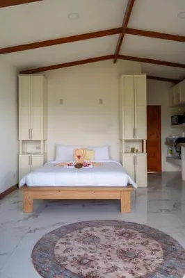 a bedroom with a bed and a rug on the floor at Hilltop Bungalow #1 W Spectacular Volcano View in El Fosforo