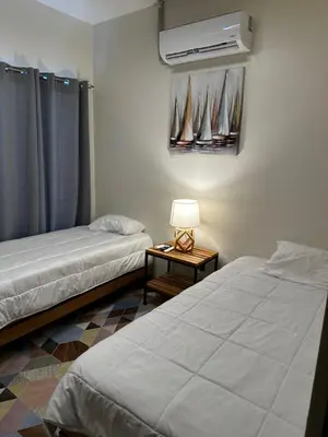 a room with two beds and a table with a lamp at Narime Costa Rica in Palmira