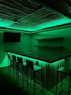 a bar with green lighting in a dark room at Narime Costa Rica in Palmira