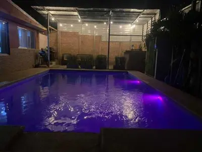 a swimming pool with purple lights in a room at Difas in Coyol
