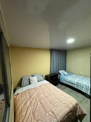 a bedroom with two beds and a yellow wall at Difas in Coyol
