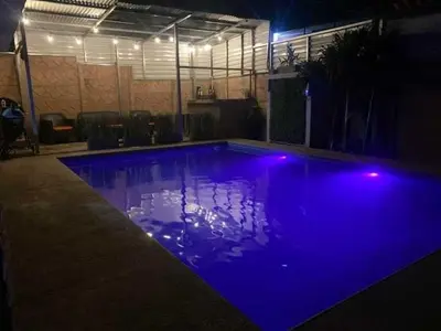 a swimming pool with blue lights in a room at Difas in Coyol