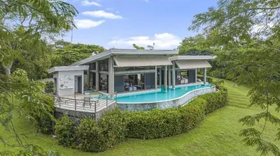 a house with a pool in the middle of a yard at Villa La Loma, Oceanview, Private Pool and AC! in Tarcoles
