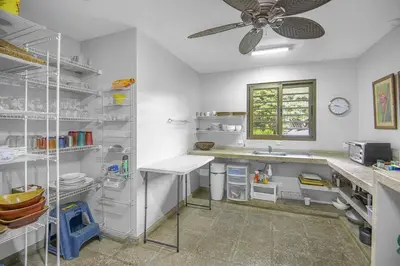 a kitchen with white shelves and a ceiling fan at Villa La Loma, Oceanview, Private Pool and AC! in Tarcoles