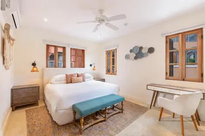 a white bedroom with a bed and a desk at Mercado 26- Ocean View Condo At Las Catalinas in Playa Danta