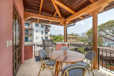 a patio with a table and chairs on a balcony at Mercado 26- Ocean View Condo At Las Catalinas in Playa Danta