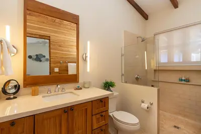 a bathroom with a sink and a toilet and a mirror at Mercado 26- Ocean View Condo At Las Catalinas in Playa Danta