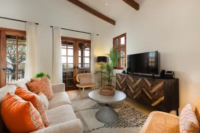 a living room with a couch and a tv at Mercado 26- Ocean View Condo At Las Catalinas in Playa Danta