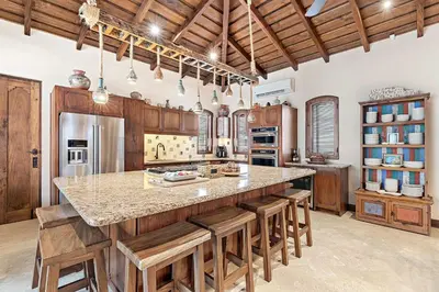 a large kitchen with a large island with wooden cabinets at Beautiful Villa Walk to Beach in Playa Danta