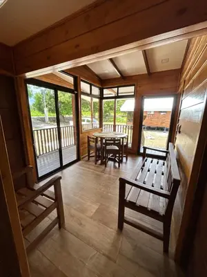 a screened in porch with a table and benches at Eco Casa Mango Lepanto #9 in Lepanto