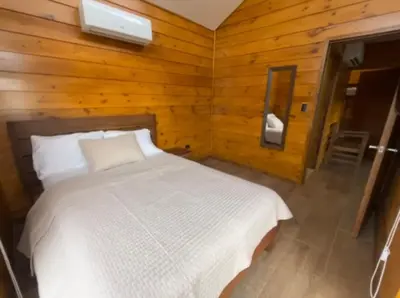 a bedroom with a white bed in a wooden wall at Eco Casa Mango Lepanto #9 in Lepanto