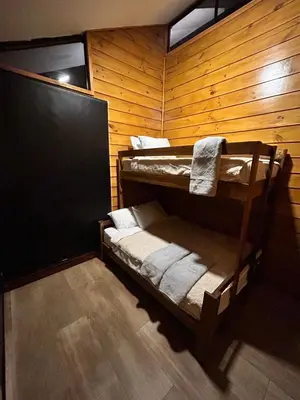 a room with two bunk beds in a wooden wall at Eco Casa Mango Lepanto #9 in Lepanto