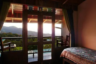 a bedroom with a window with a view of a mountain at Camino Nuevo Monteverde Ecolodge in Monteverde Costa Rica