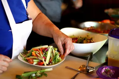 a person holding a plate of food with a salad at Camino Nuevo Monteverde Ecolodge in Monteverde Costa Rica
