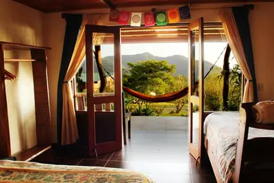 a bedroom with a bed and a window with a view at Camino Nuevo Monteverde Ecolodge in Monteverde Costa Rica