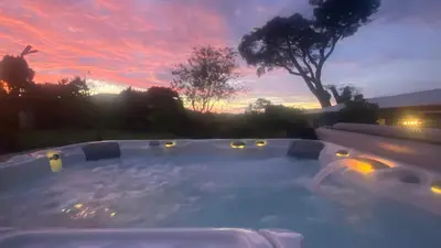 a hot tub in a backyard with a sunset at Casa Marigold -Apartamento Bondad in Alajuela City