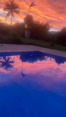 a sunset with a reflection in a pool of water at Casa Marigold -Apartamento Bondad in Alajuela City