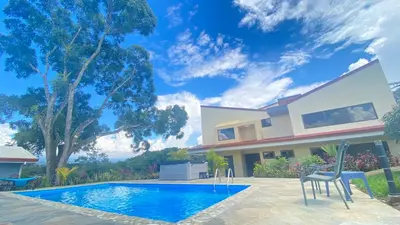 a villa with a swimming pool and a house at Casa Marigold -Apartamento Bondad in Alajuela City