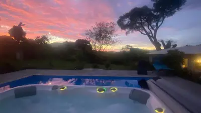 a sunset over a swimming pool in a backyard at Casa Marigold -Apartamento Bondad in Alajuela City