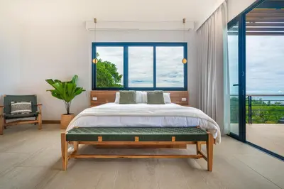 a bedroom with a bed and a large window at Villa del Cielo - by Pura Villas in Uvita