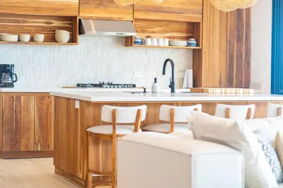a kitchen with wooden cabinets and a counter top at Villa del Cielo - by Pura Villas in Uvita