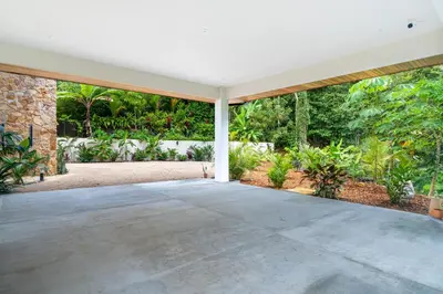 an empty house with a large patio with trees at Villa del Cielo - by Pura Villas in Uvita