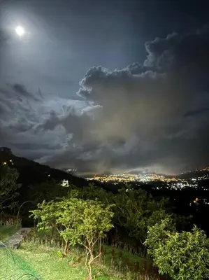 a view of a city at night with the moon at Private Costa Rica Mountain House Pool & Stunning Views in Turrialba