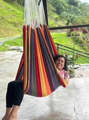a young girl is sitting in a swing at Private Costa Rica Mountain House Pool & Stunning Views in Turrialba