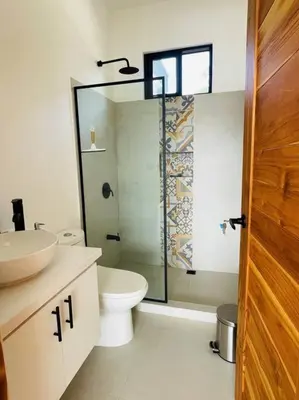 a bathroom with a toilet and a glass shower at Casa Paloma in Playa Grande