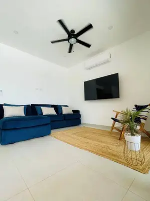 a living room with a blue couch and a flat screen tv at Casa Paloma in Playa Grande