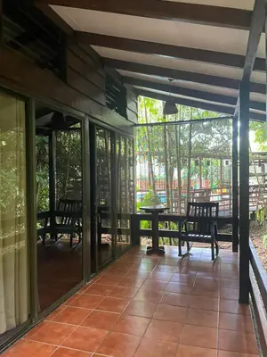 a screened in porch with a table and chairs at Hotel Brisas del Rio Guápiles in Jiménez